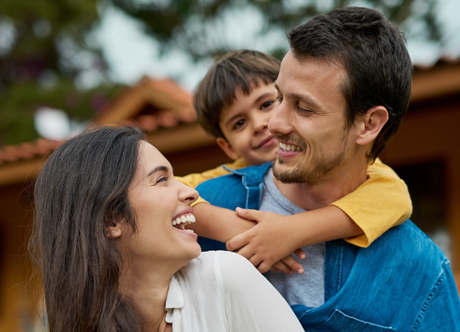 A happy family of three smiling and spending time together.