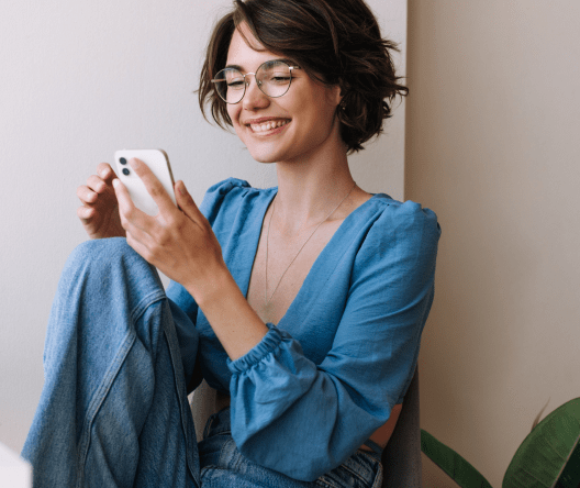 A smiling girl looking at her mobile phone.